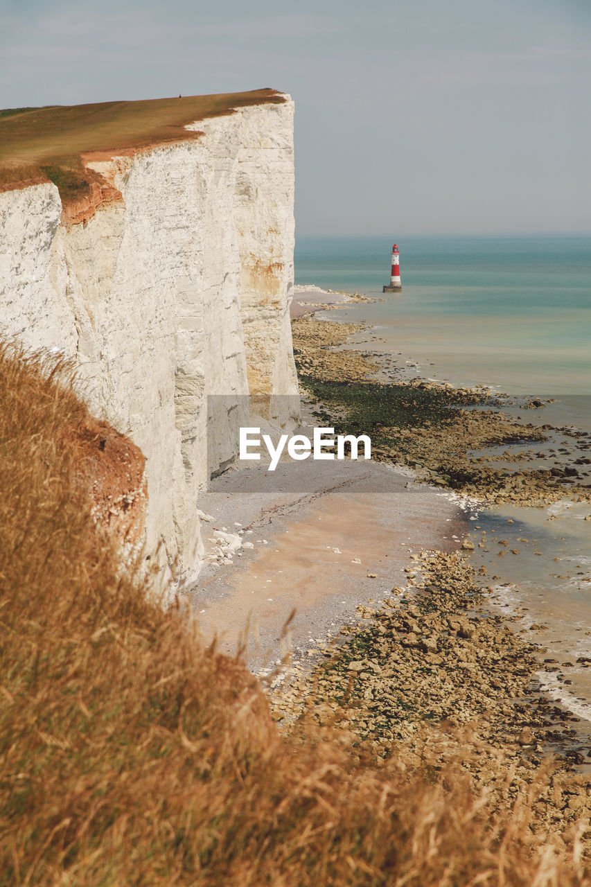 Sea by cliff against sky