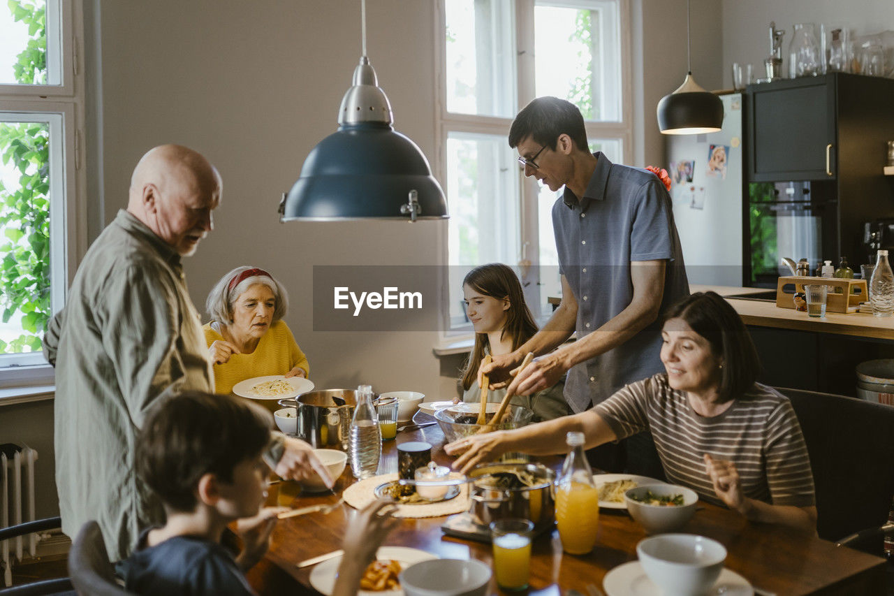 Multi-generation family having dinner at dining table in home