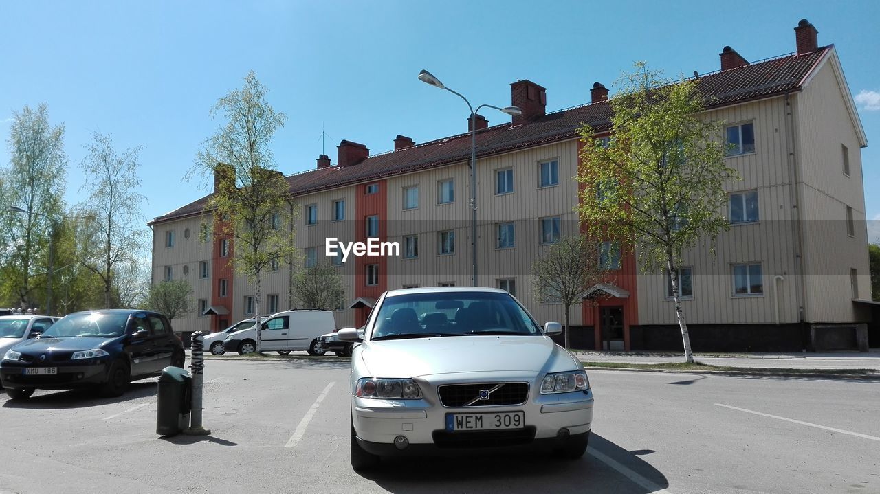 CARS ON ROAD AGAINST BUILDINGS