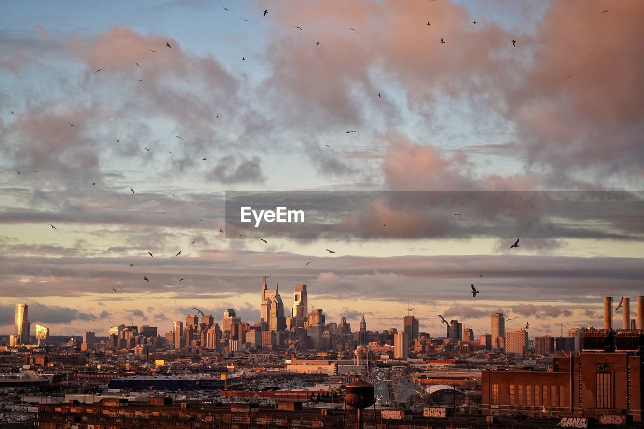 Panoramic view of buildings against cloudy sky