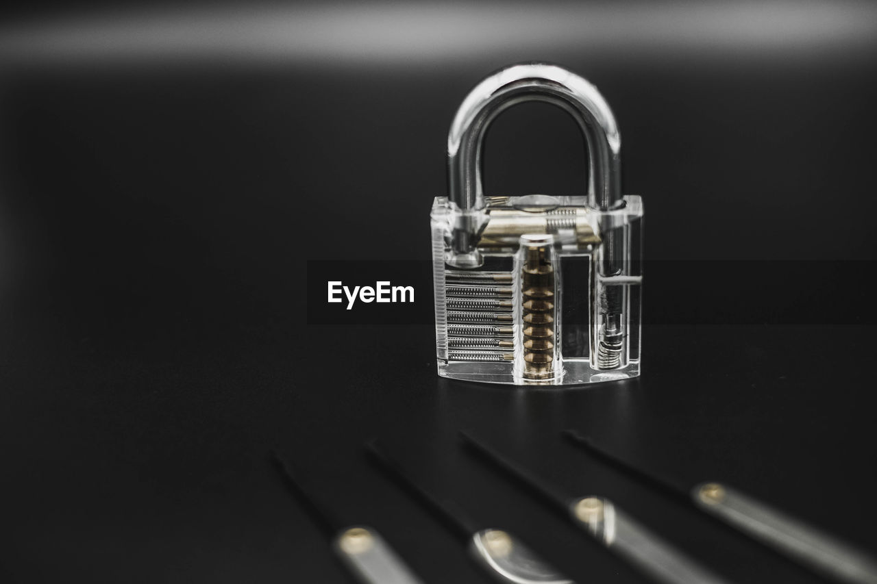 Padlock with tools on black background