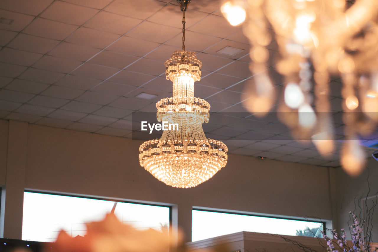 Low angle view of illuminated pendant light hanging from ceiling