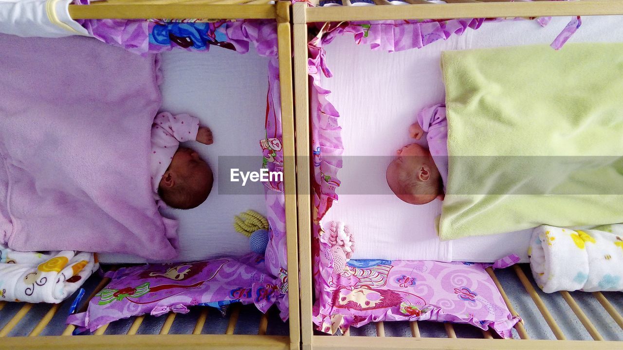 HIGH ANGLE VIEW OF BABY SLEEPING ON BED