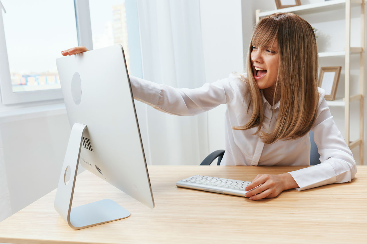 side view of young woman using laptop at table