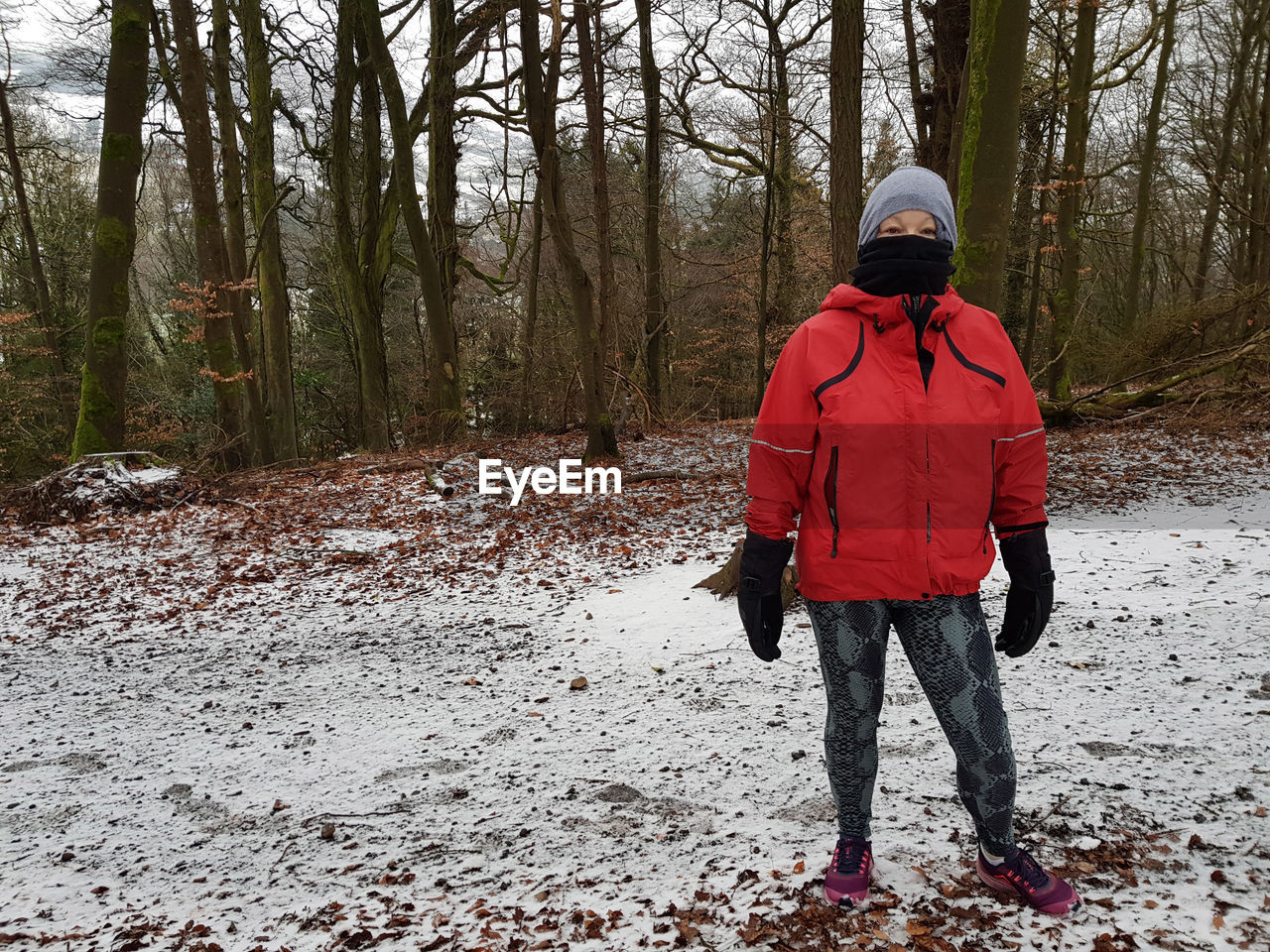 REAR VIEW OF MAN STANDING IN SNOW COVERED LAND