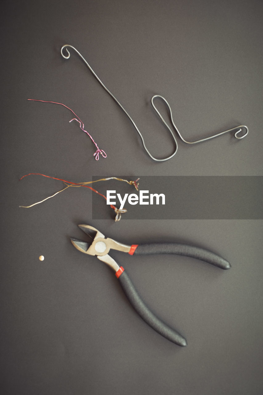 Pliers and wire flowers on table