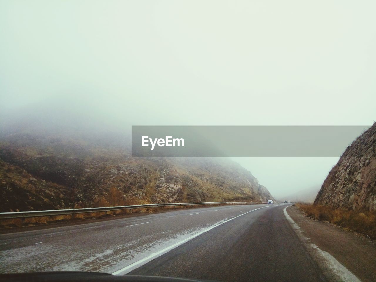 Road by mountains against clear sky