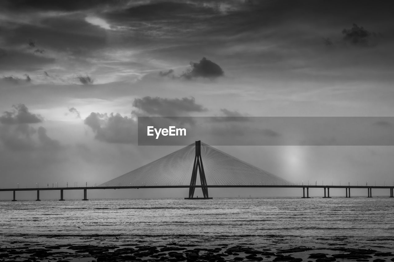 Bridge over calm sea against sky