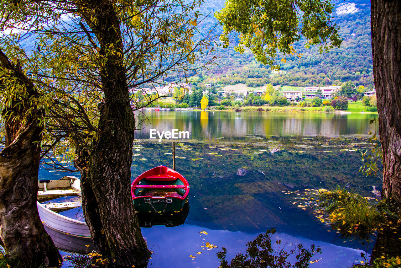 Romantically abandoned red and white boats on the shores of the revine lakes, treviso, italy