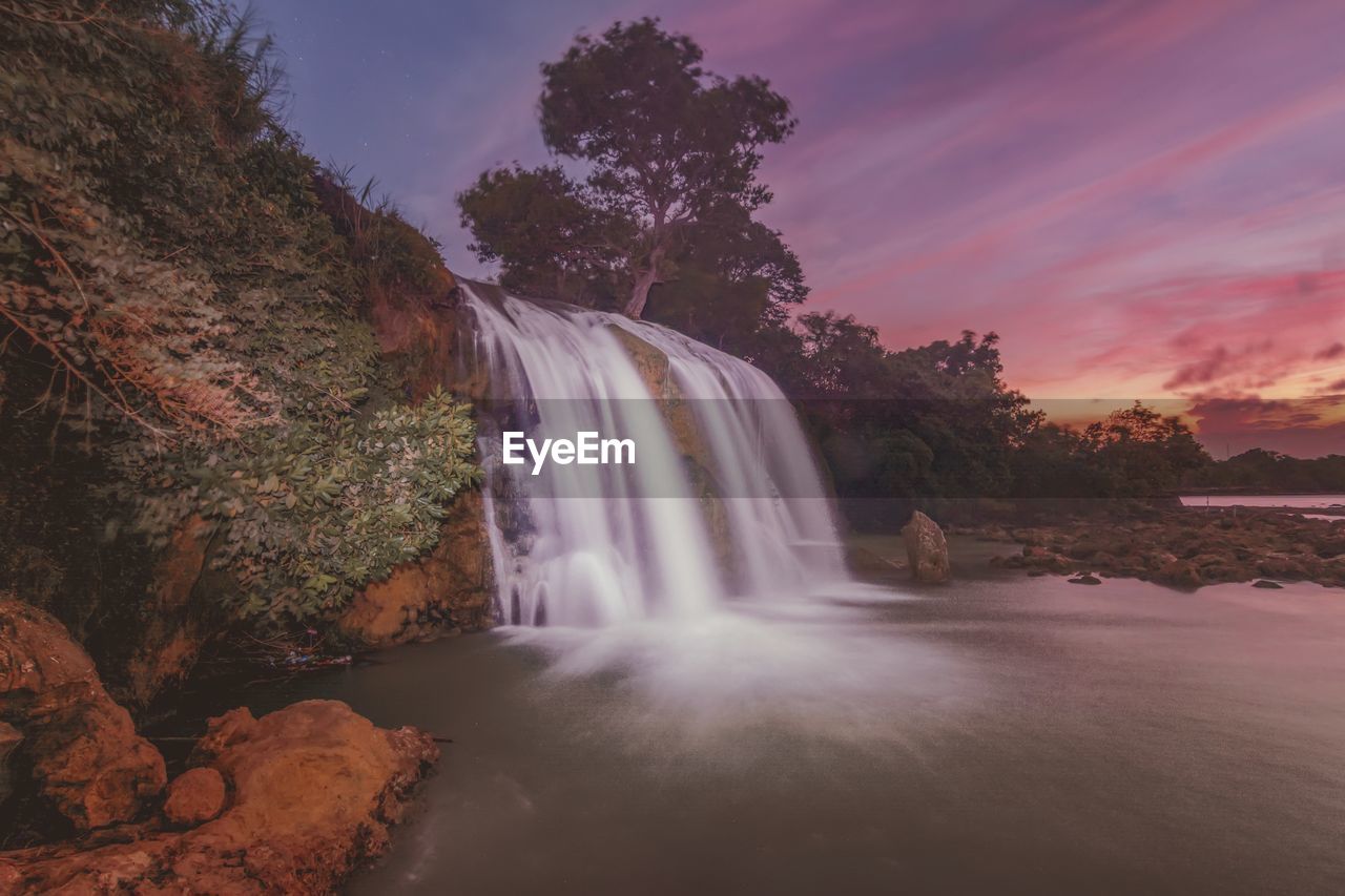 Scenic view of toroan waterfall against sky during sunset