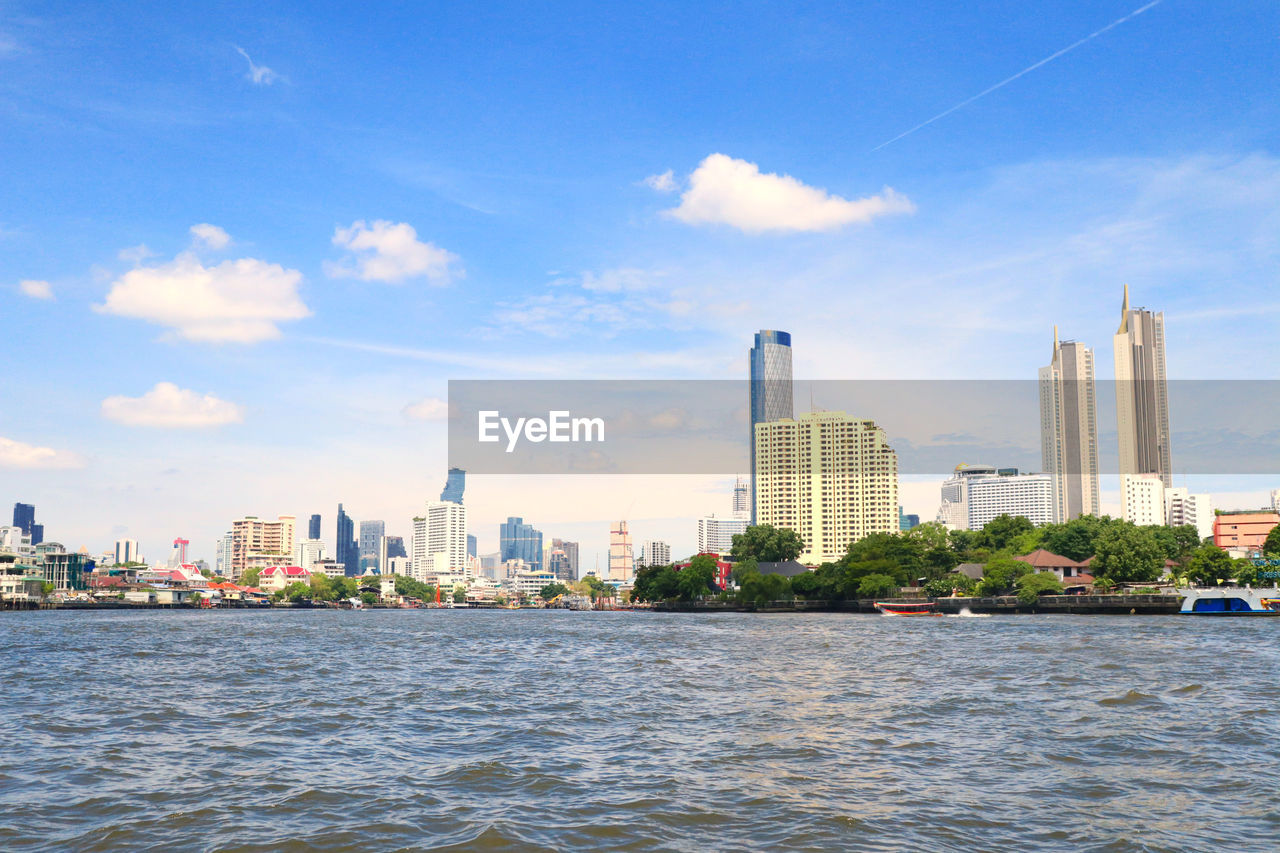 SEA AND BUILDINGS AGAINST SKY IN CITY