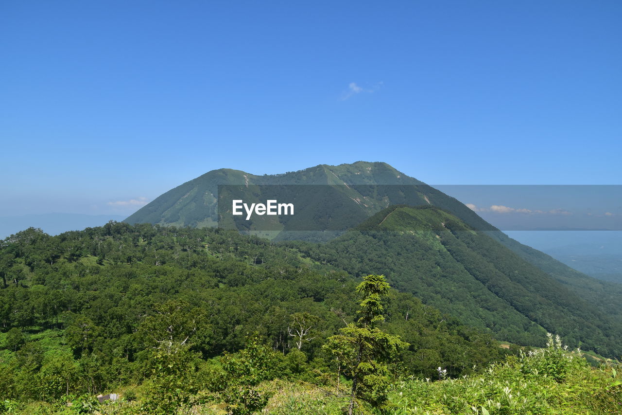 Scenic view of mountains against blue sky