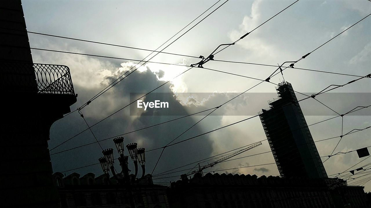 LOW ANGLE VIEW OF SILHOUETTE CABLES AGAINST SKY