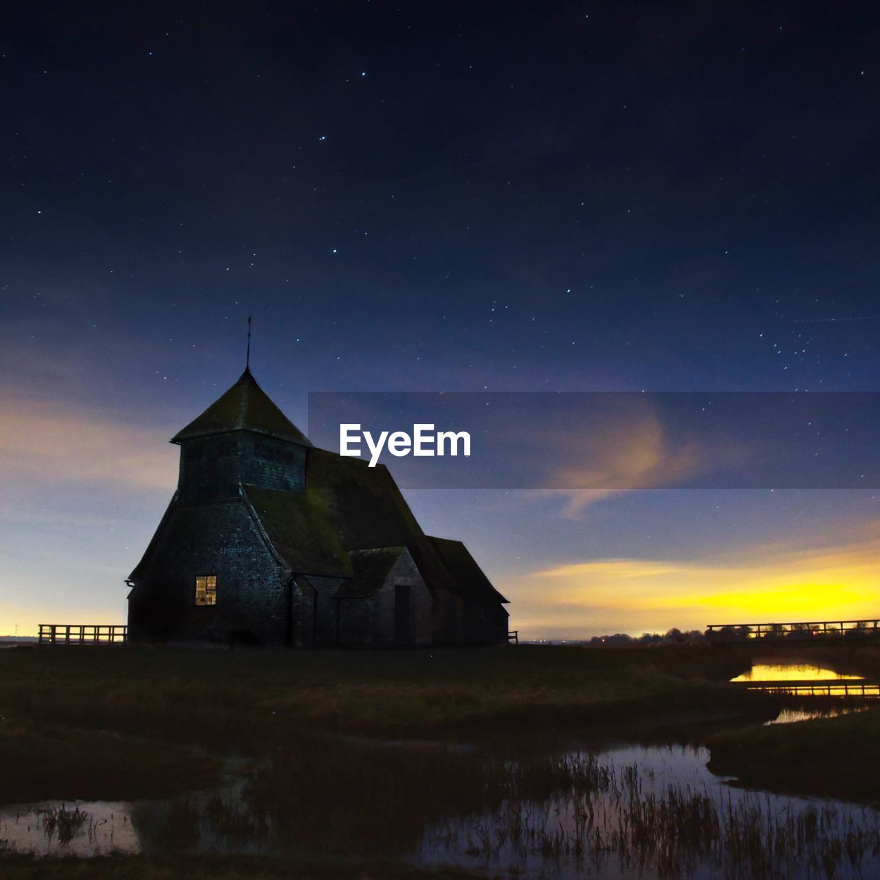 Houses on field against sky at night