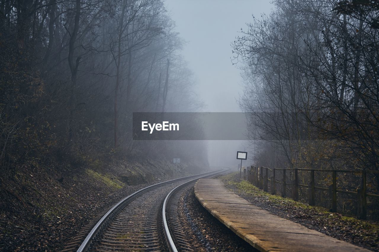 Railway in mysterious fog. old railroad station in the middle of forest in autumn.