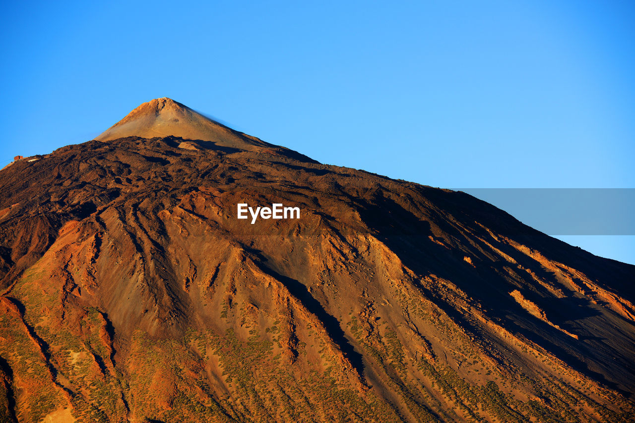 Rocky mountain at el teide national park against clear blue sky