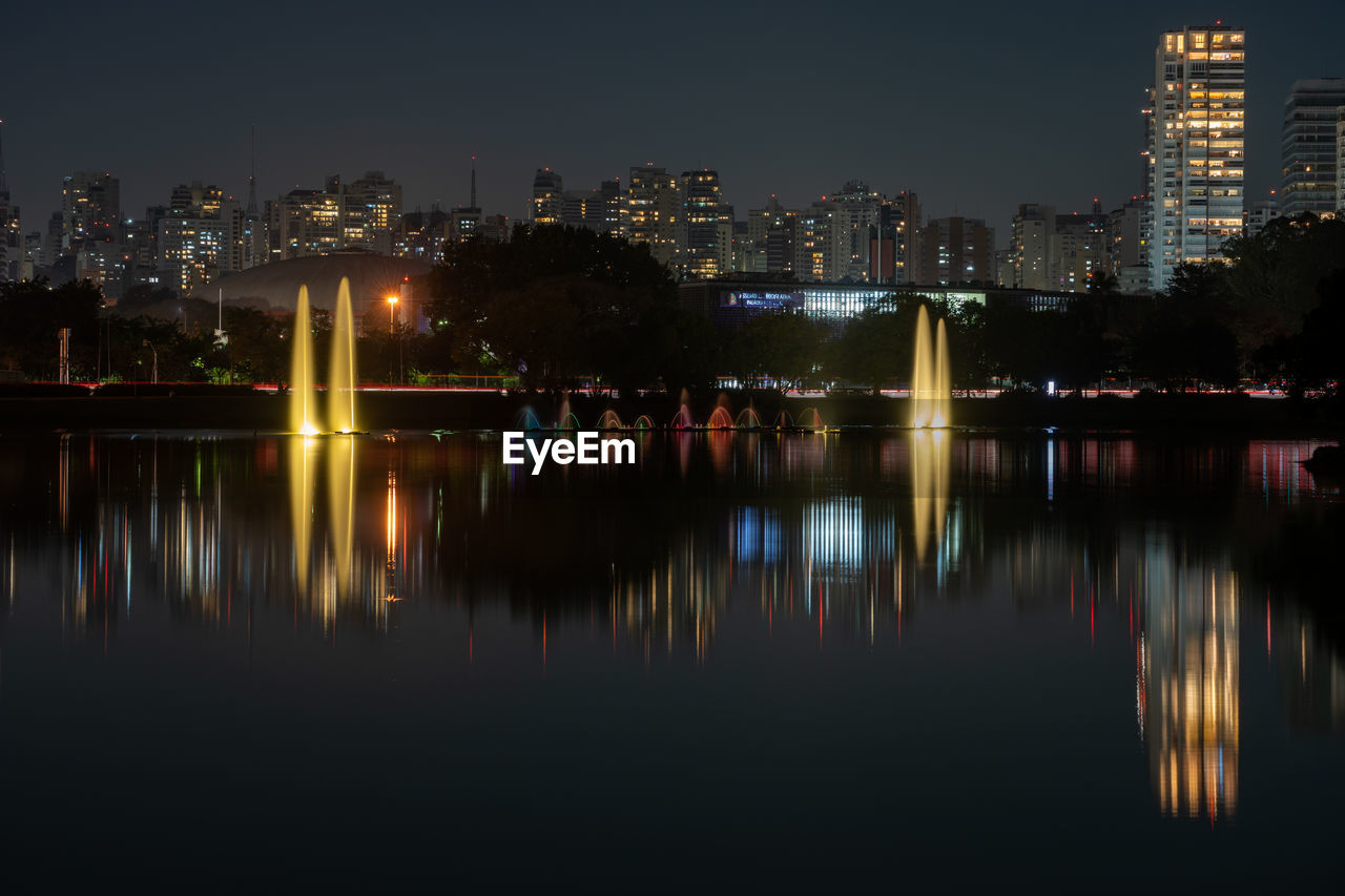 Reflection of illuminated buildings in river at night