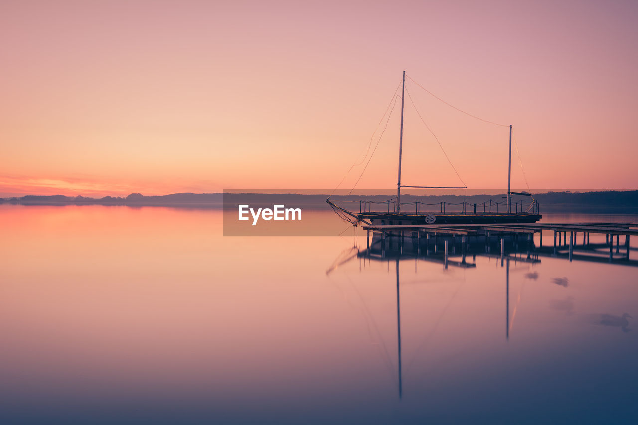 Sailboat in sea at sunset