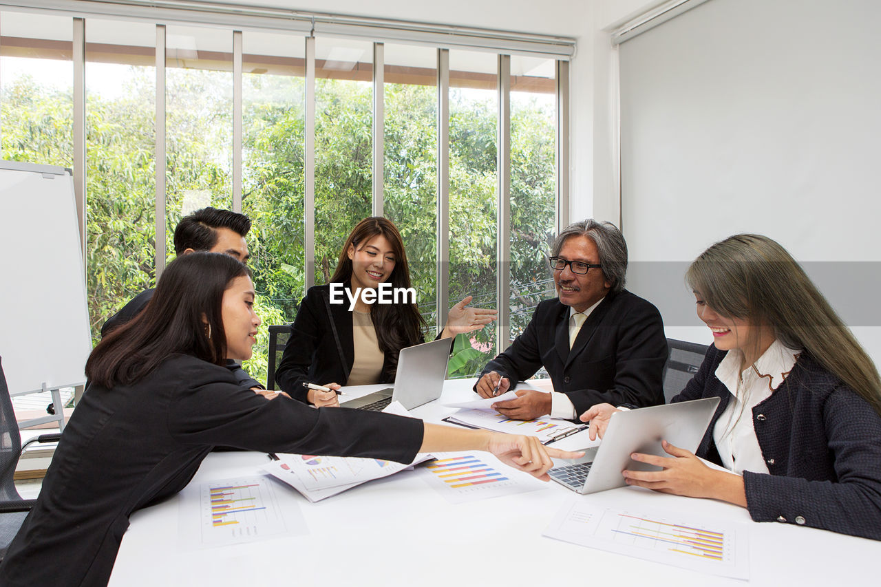 People discussing over laptop on table