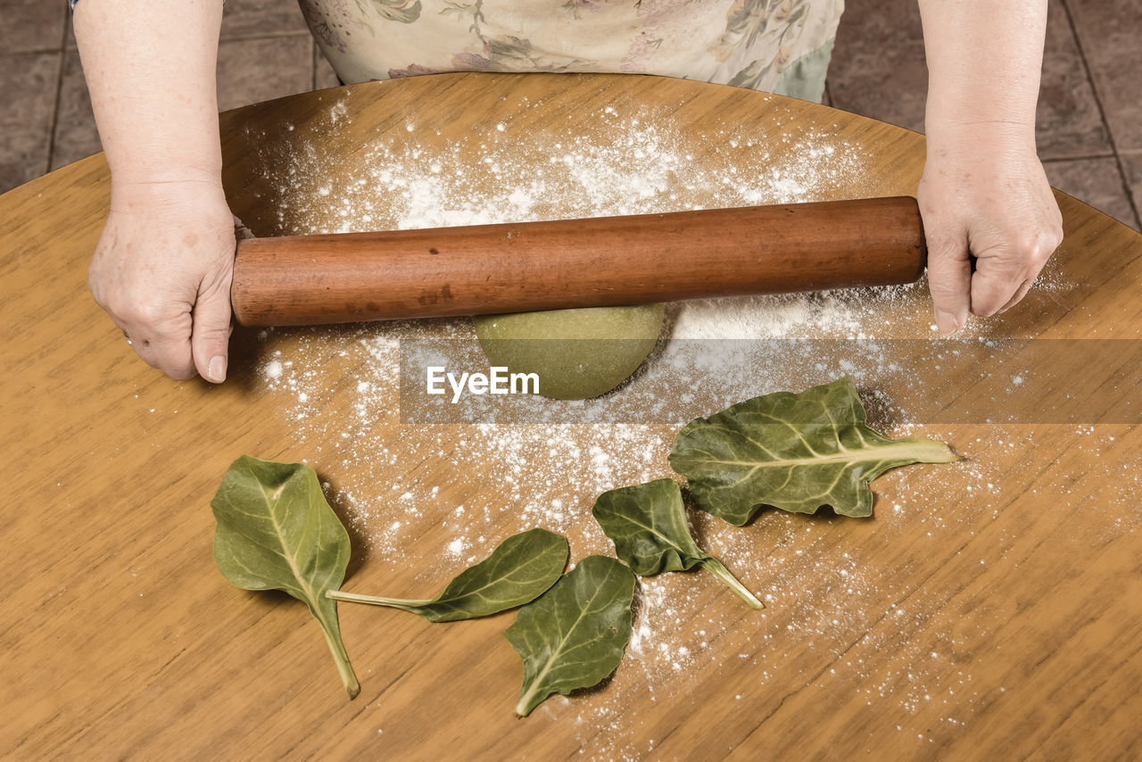 cropped hands of man preparing food on table