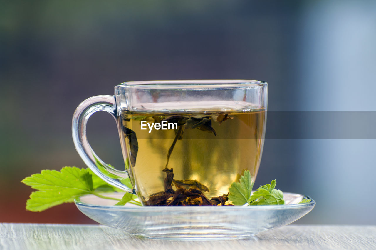 CLOSE-UP OF TEA IN GLASS ON TABLE AT HOME