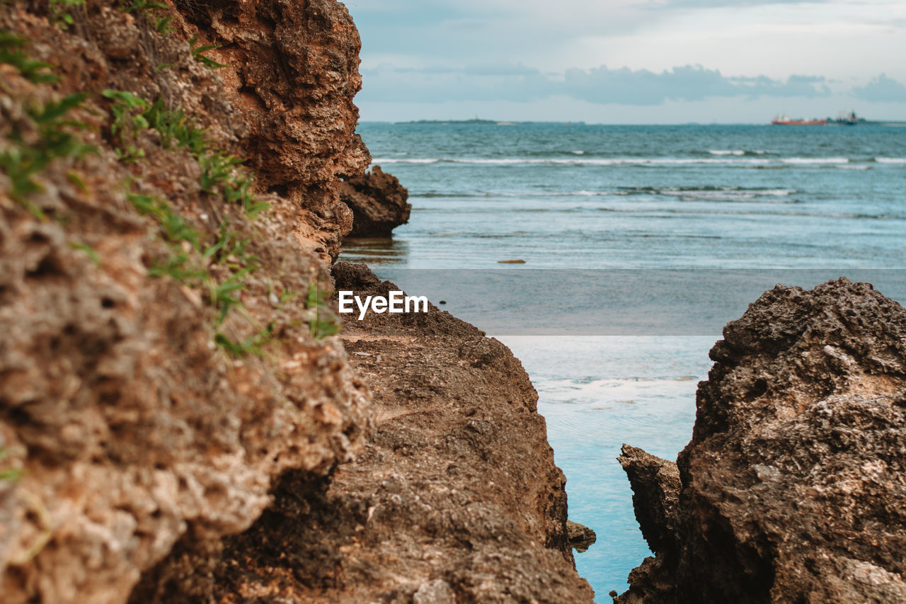 sea, water, land, rock, beach, sky, cliff, beauty in nature, coast, scenics - nature, nature, shore, terrain, ocean, rock formation, cloud, tranquility, body of water, coastline, no people, travel destinations, tranquil scene, day, outdoors, horizon over water, travel, horizon, bay, environment, geology, wave, motion, idyllic, cove
