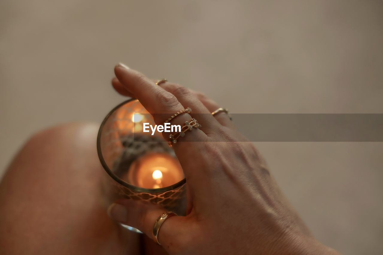 CLOSE-UP OF WOMAN HAND HOLDING BURNING CANDLE