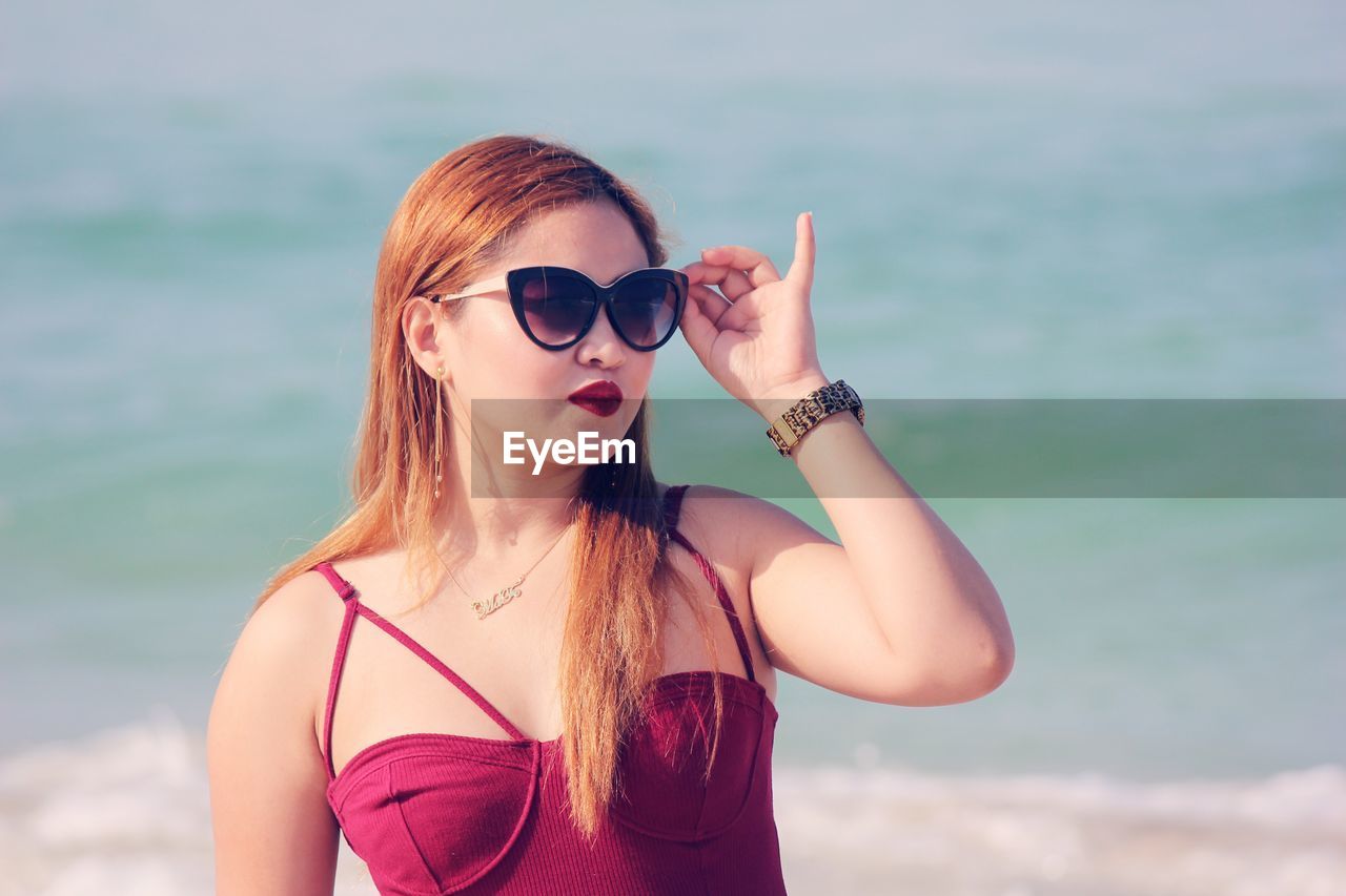 Young woman with sunglasses against sky