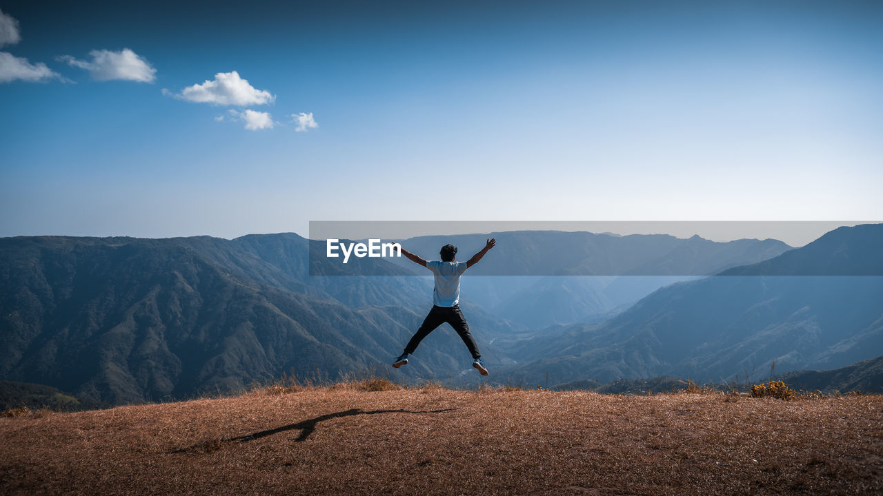 Man jumping against mountains
