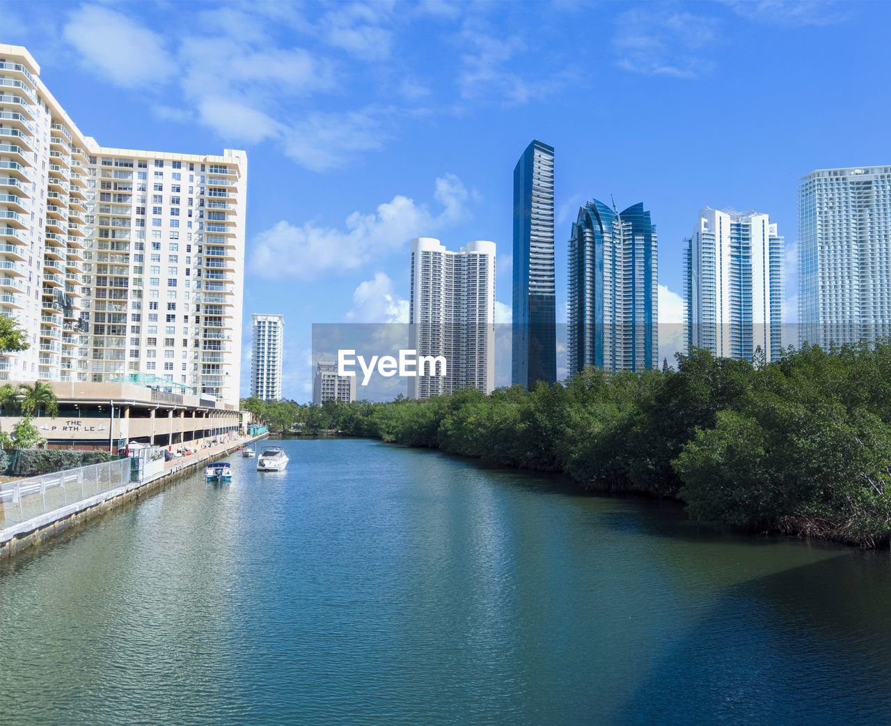 River amidst buildings against blue sky