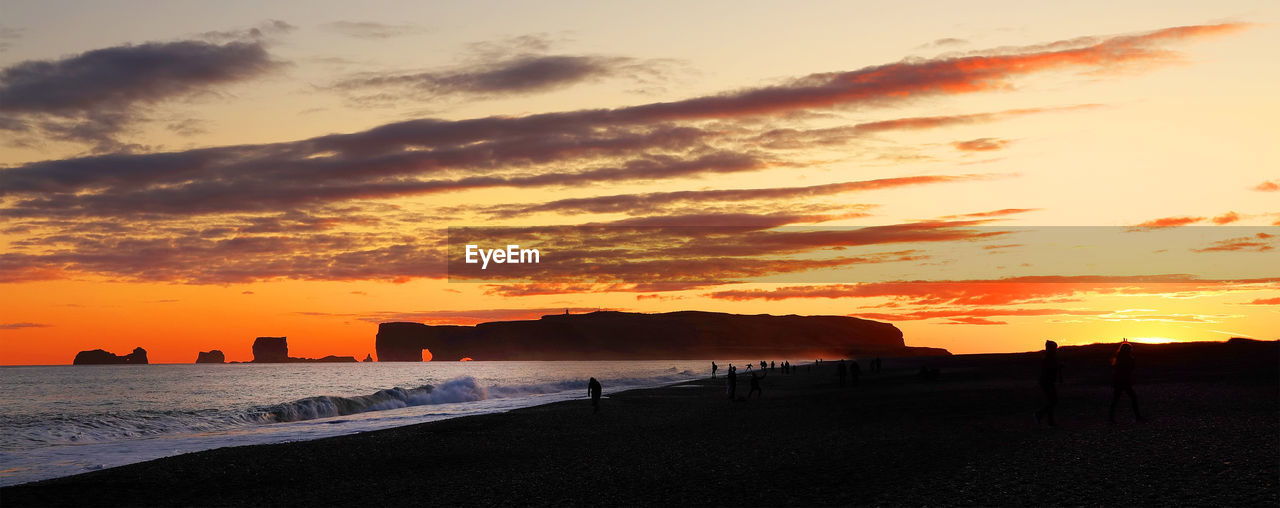 SCENIC VIEW OF BEACH AGAINST DRAMATIC SKY