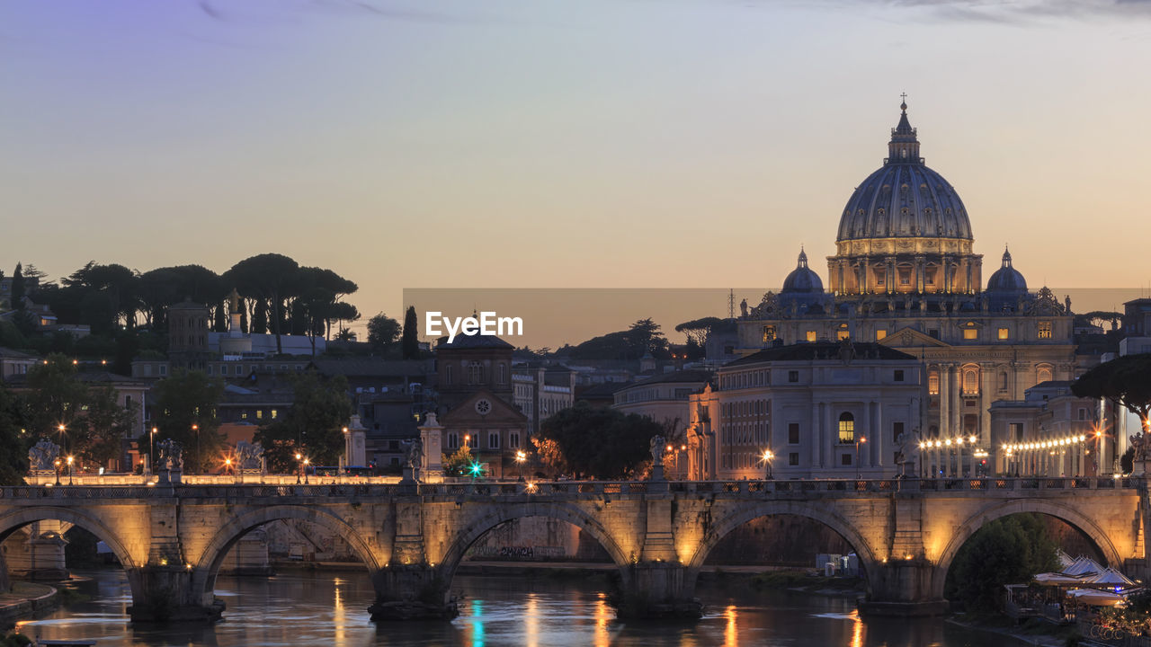 St peters basilica over tiber river during sunset in city