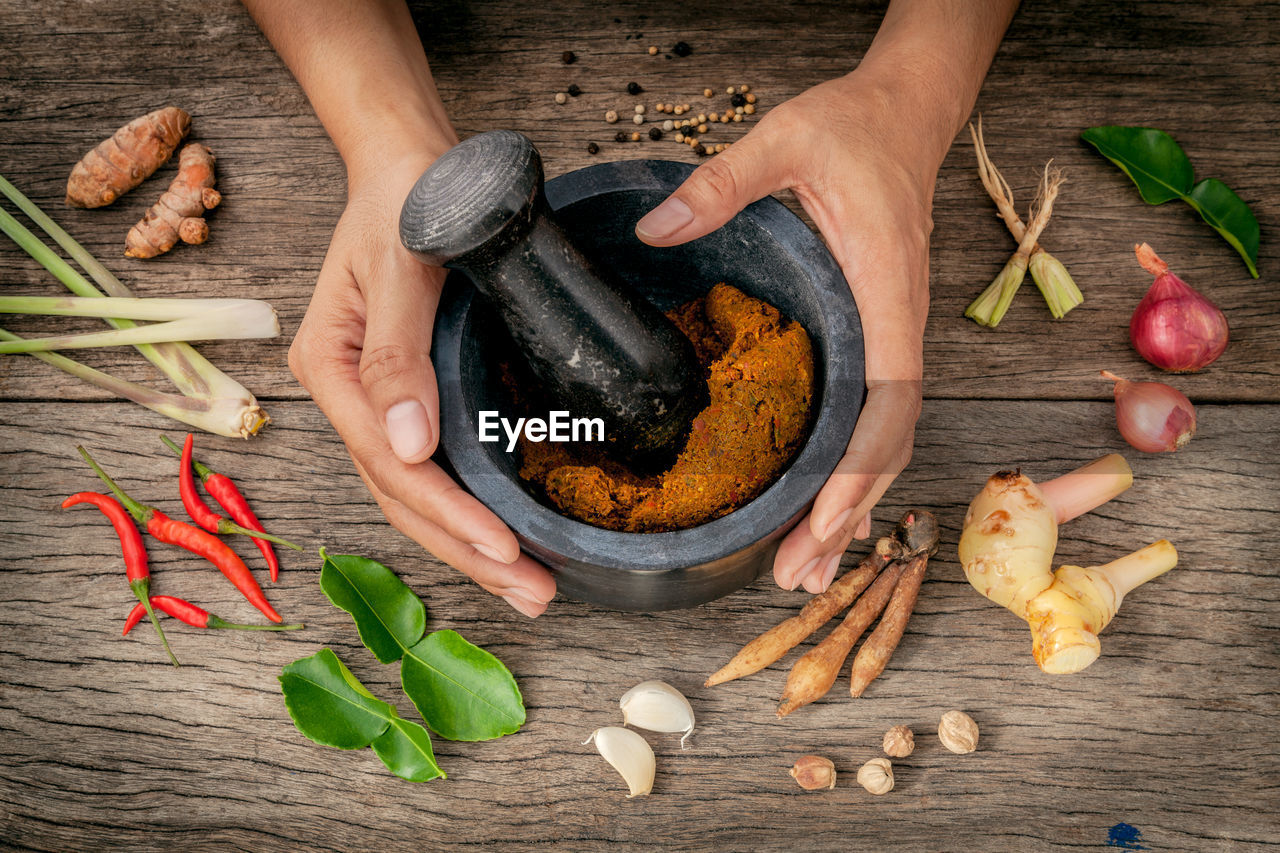 Cropped hands of person mixing spices on table