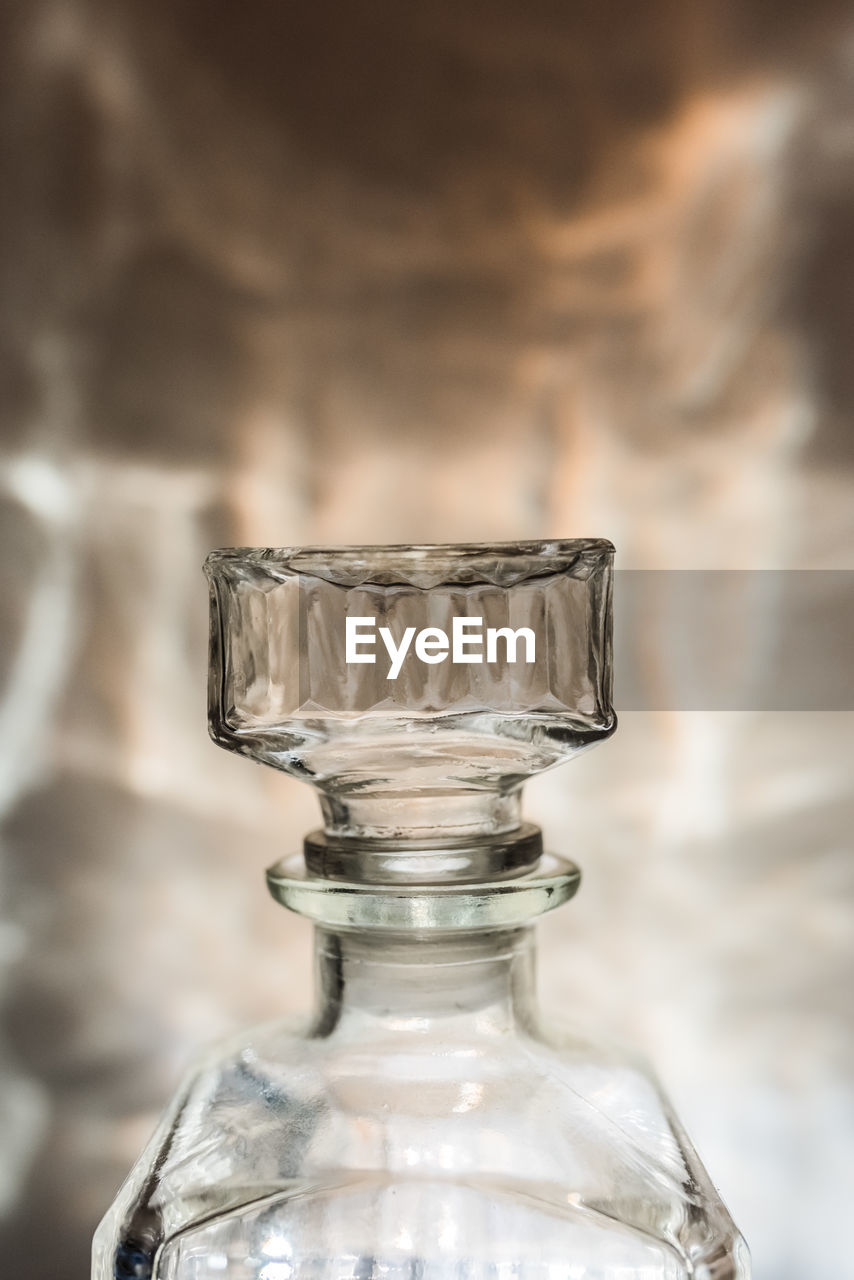 CLOSE-UP OF GLASS OF BOTTLE ON TABLE