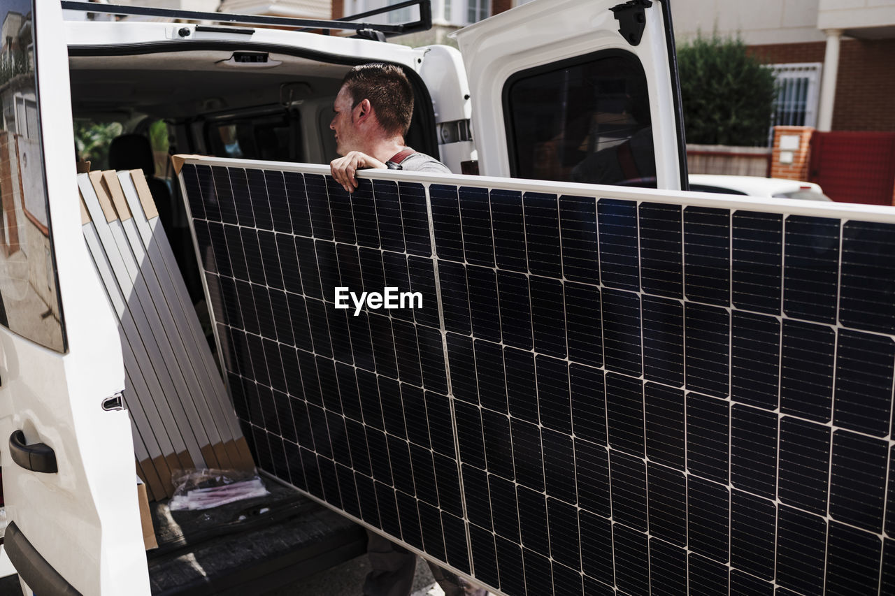 Technician unloading solar panels from van