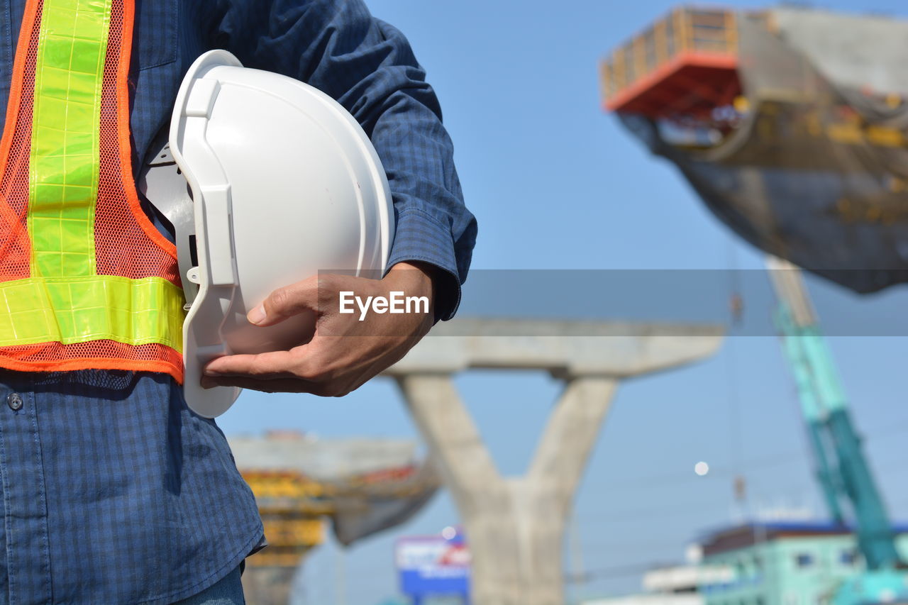 Businessman holding hard hat building estate construction background