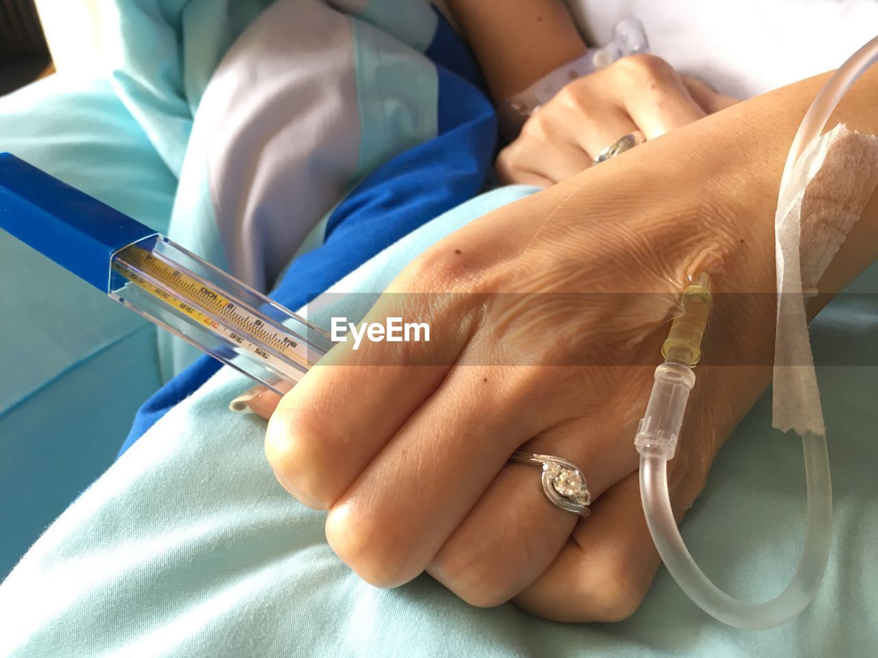 Cropped hand of woman with iv drip in hospital