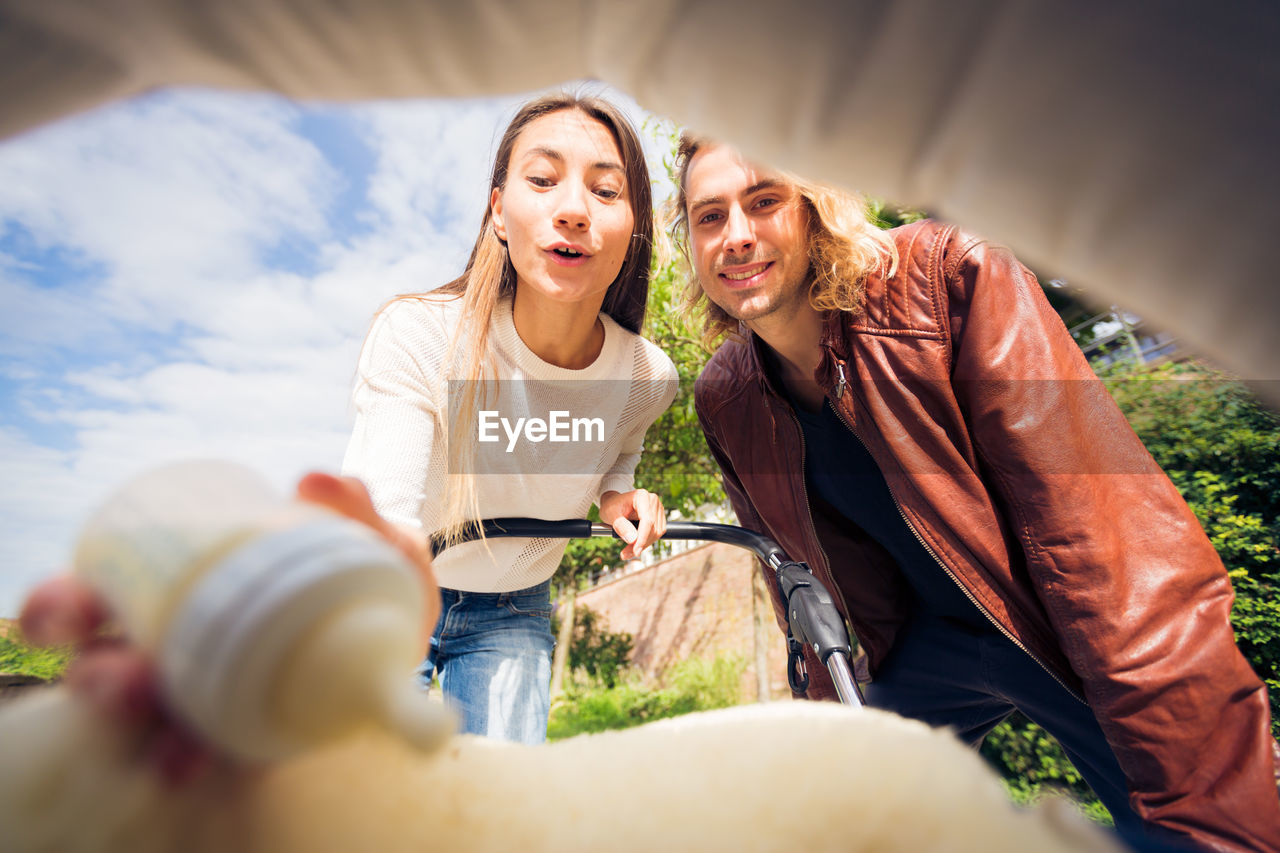 Young couple with baby stroller outdoors