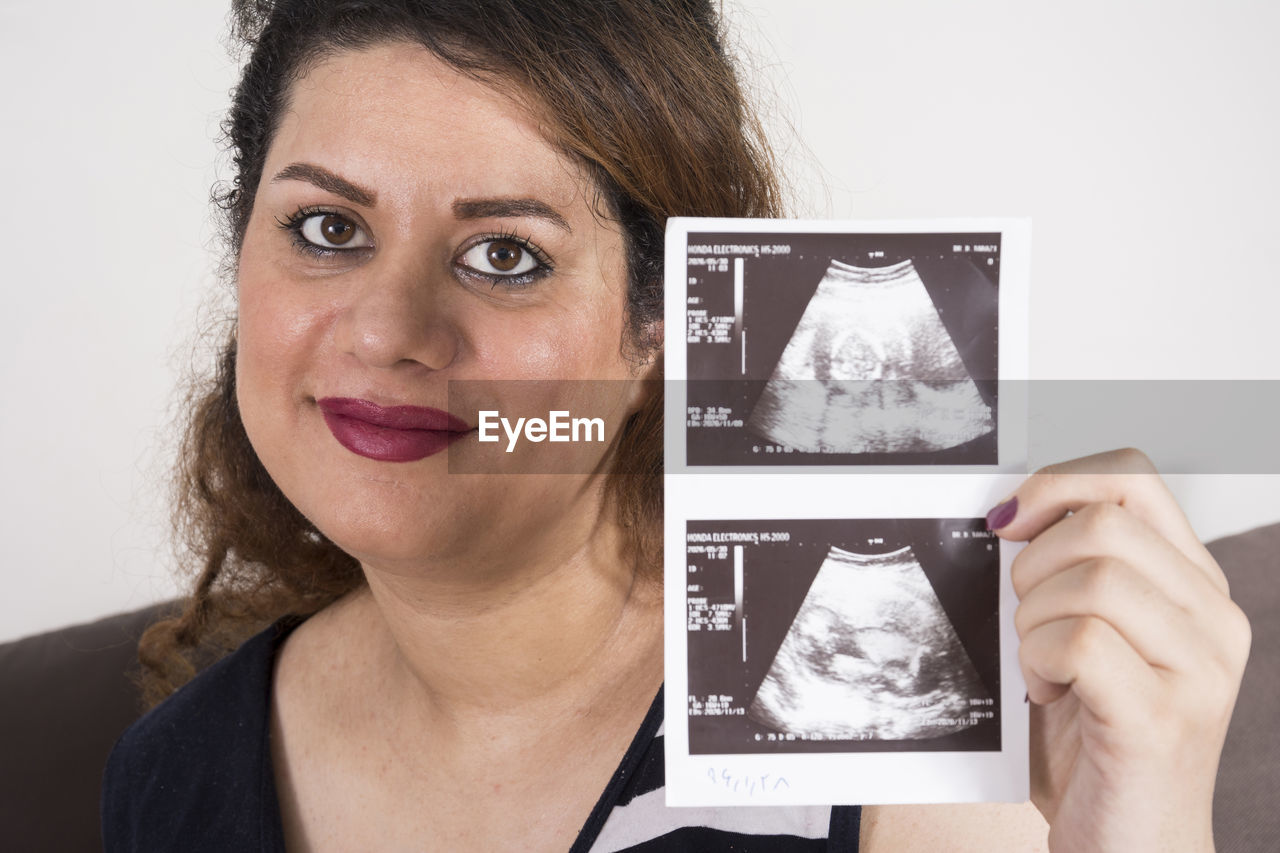 Portrait of woman holding x ray at home