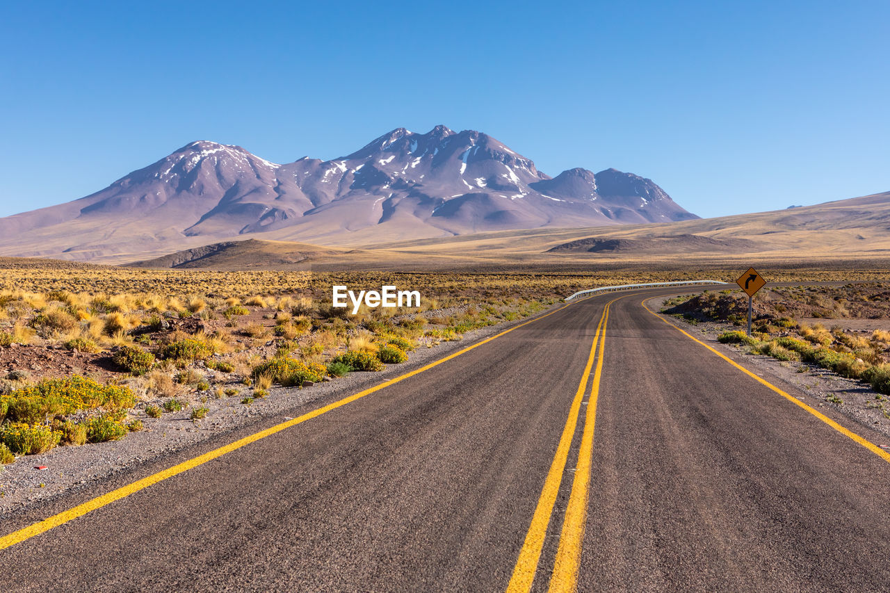 ROAD PASSING THROUGH A DESERT AGAINST SKY