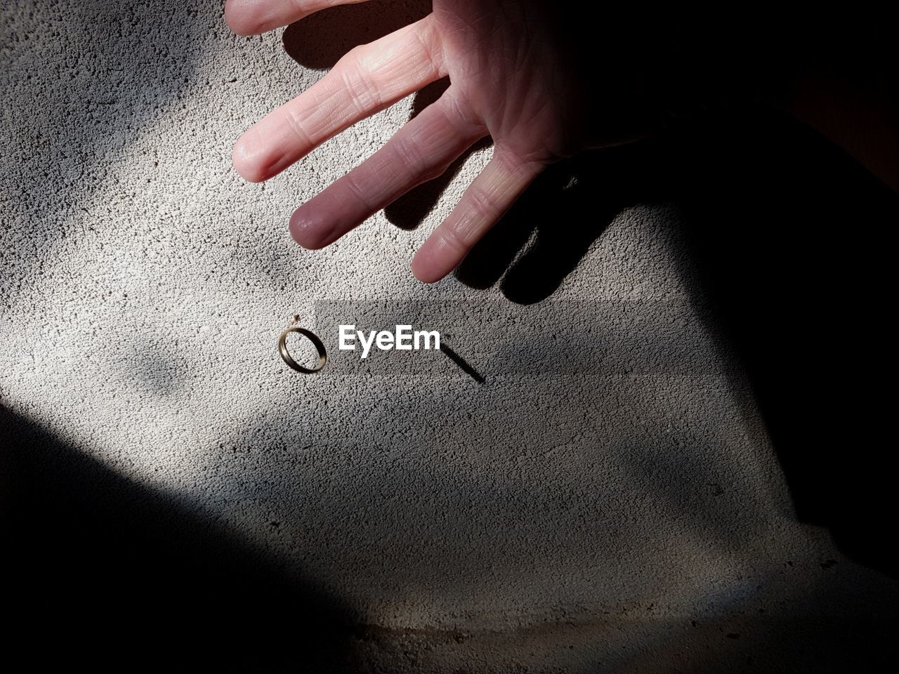 Cropped hand throwing ring against wall