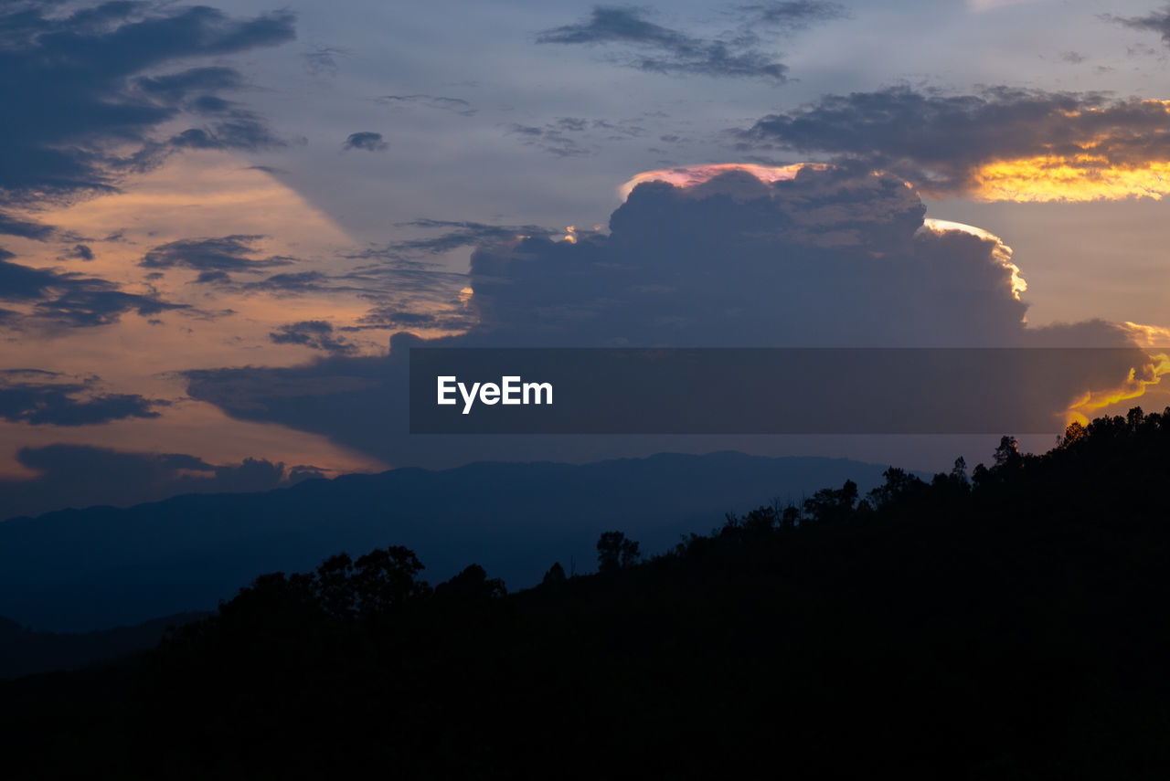 SCENIC VIEW OF SILHOUETTE MOUNTAIN AGAINST DRAMATIC SKY