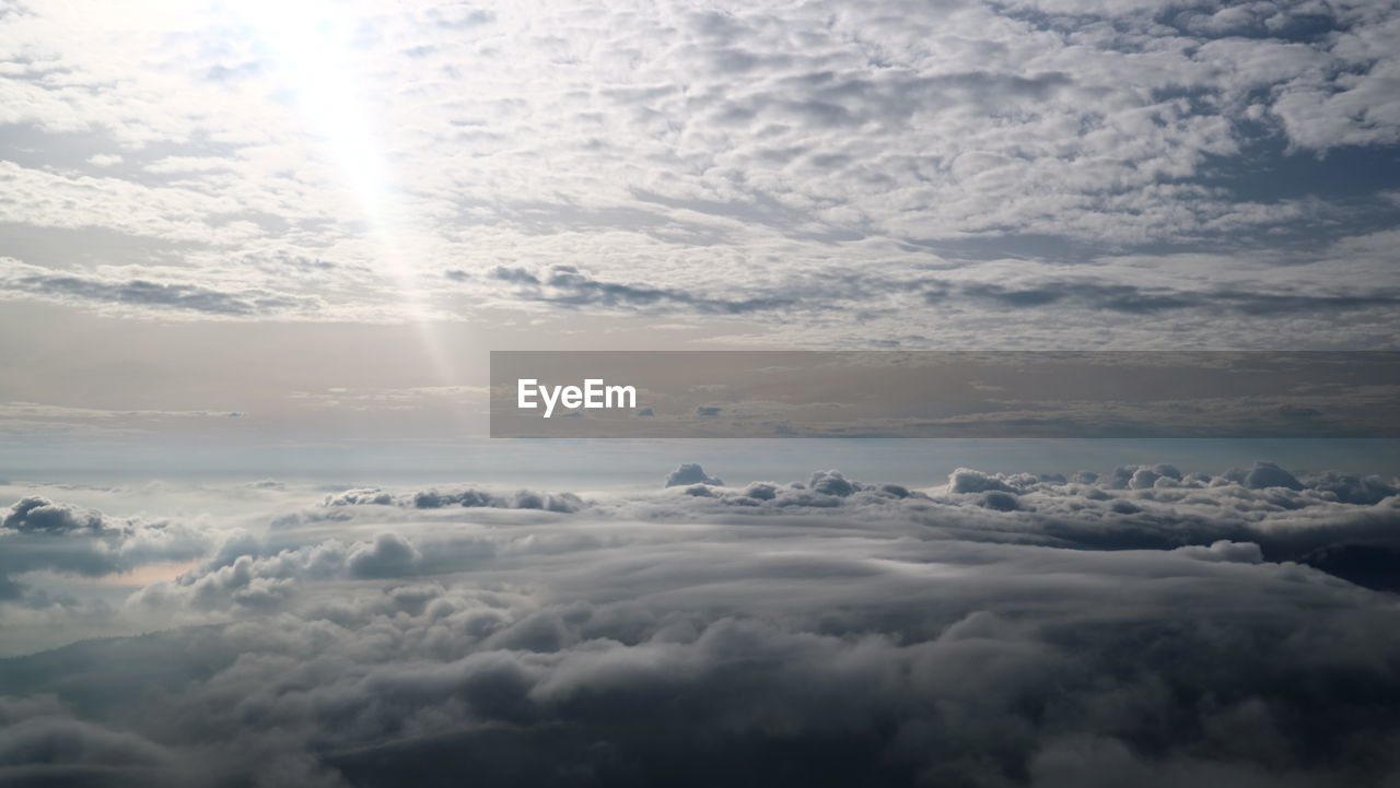 Aerial view of clouds over landscape during sunset