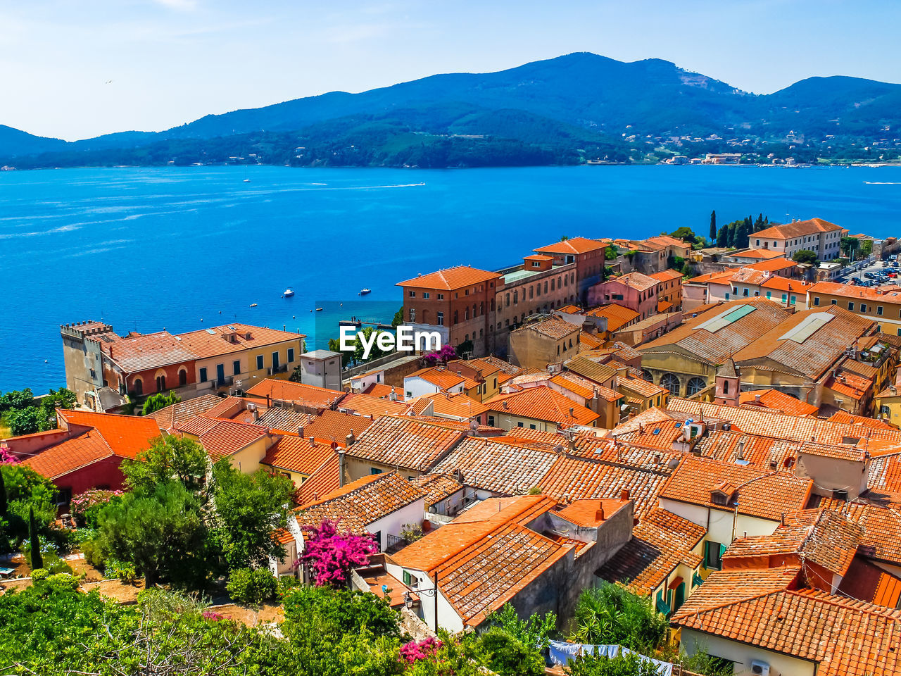 High angle view of townscape by sea against sky