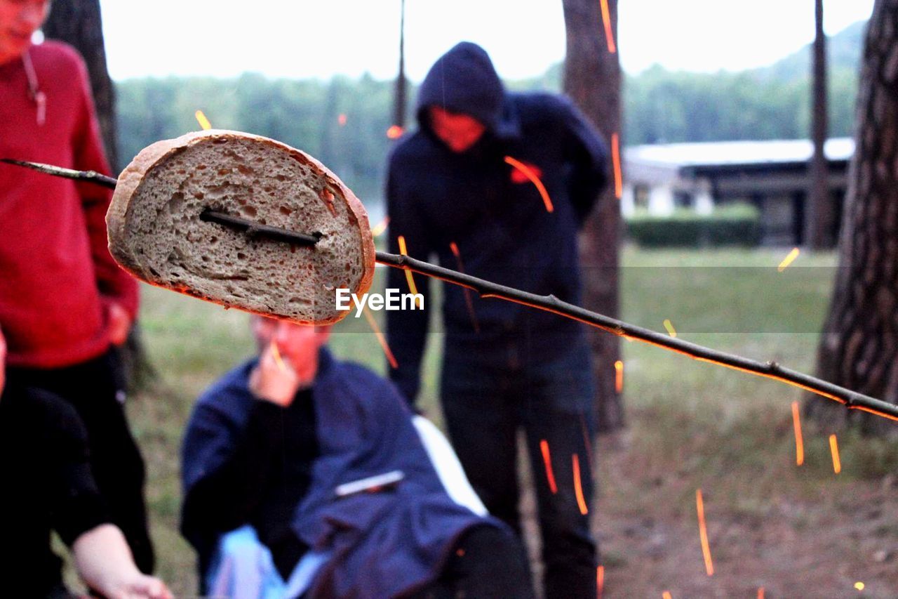 Close-up of bread on skewer over campfire