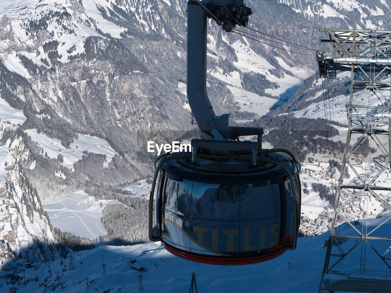 OVERHEAD CABLE CARS IN SNOW COVERED MOUNTAINS