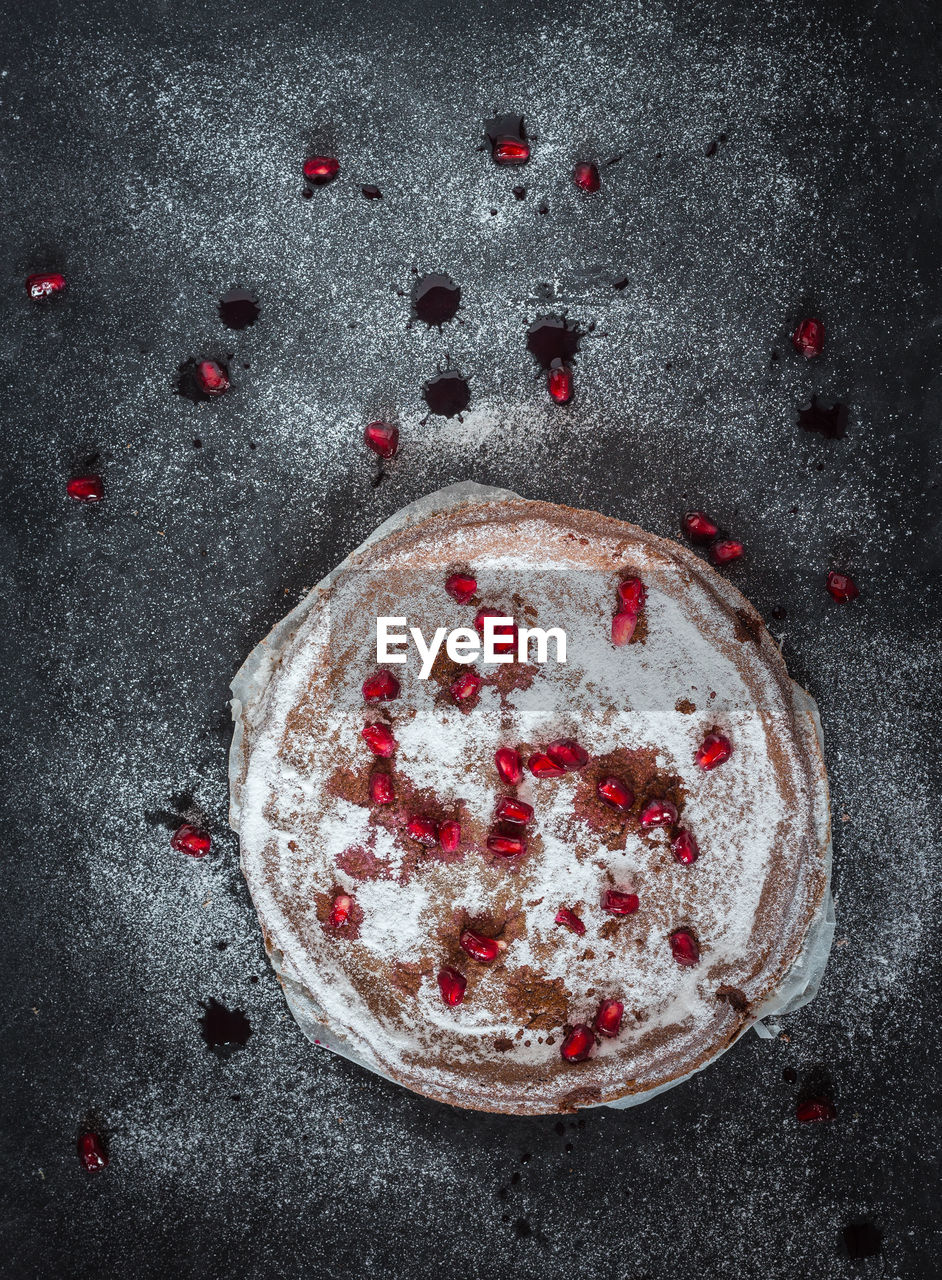 Directly above of chocolate cake with pomegranate seeds on table