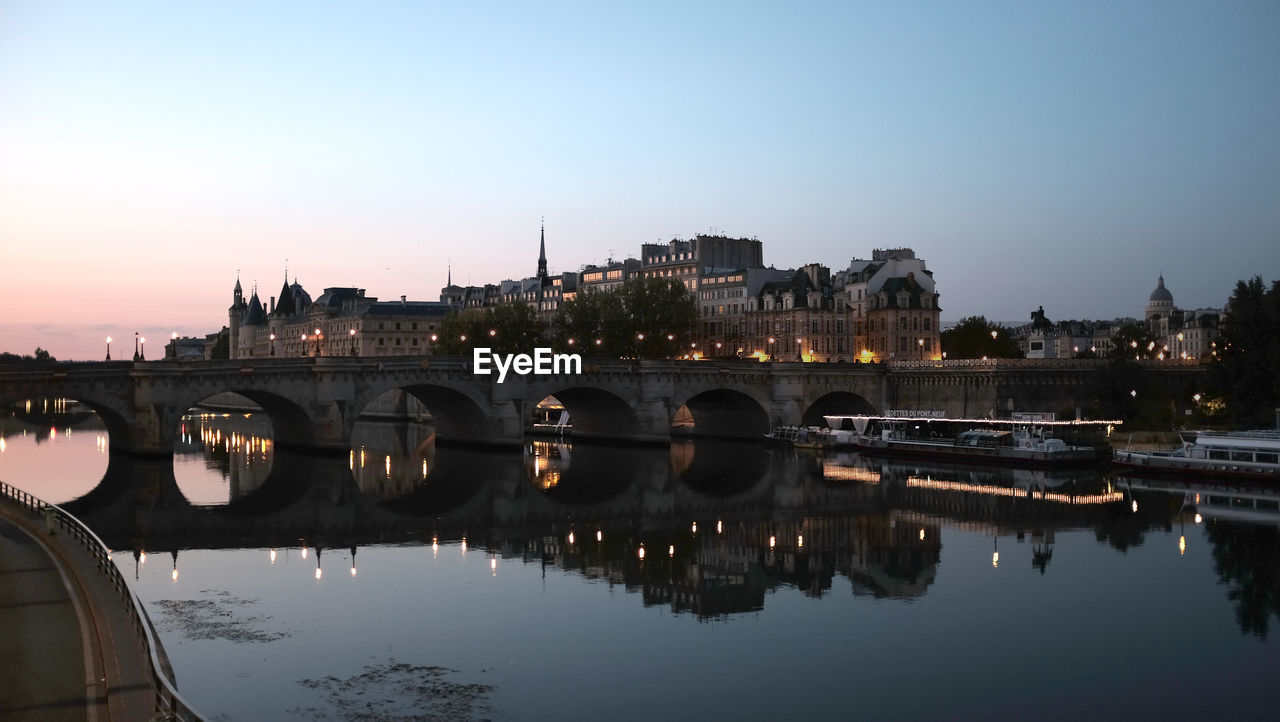 Bridge over river in city against clear sky