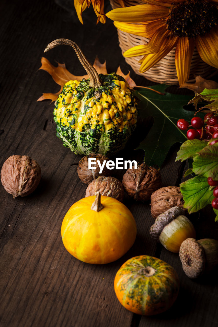 HIGH ANGLE VIEW OF PUMPKINS IN CONTAINER ON TABLE