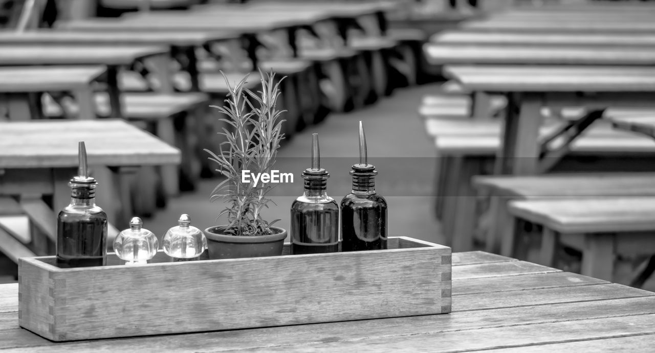 Close-up of bottles with potted plant in box on table